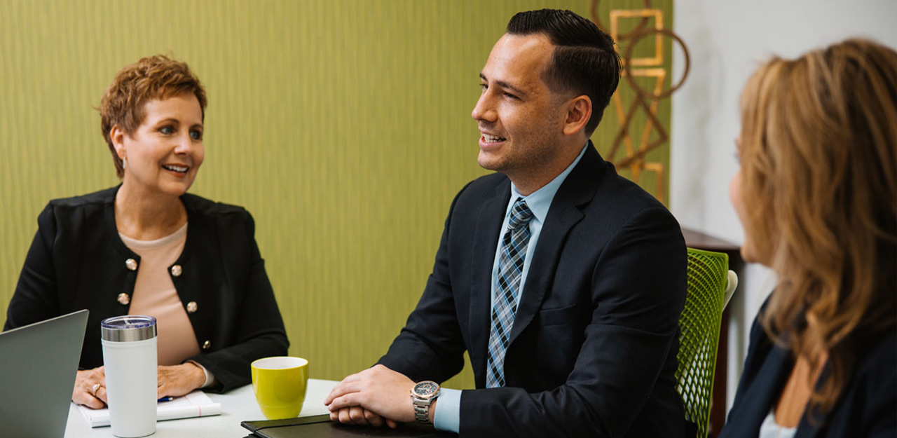 Sheri and Spencer Welsh discuss at conference room table.